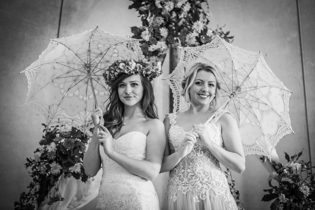 Two brides with lace umbrellas in black & white