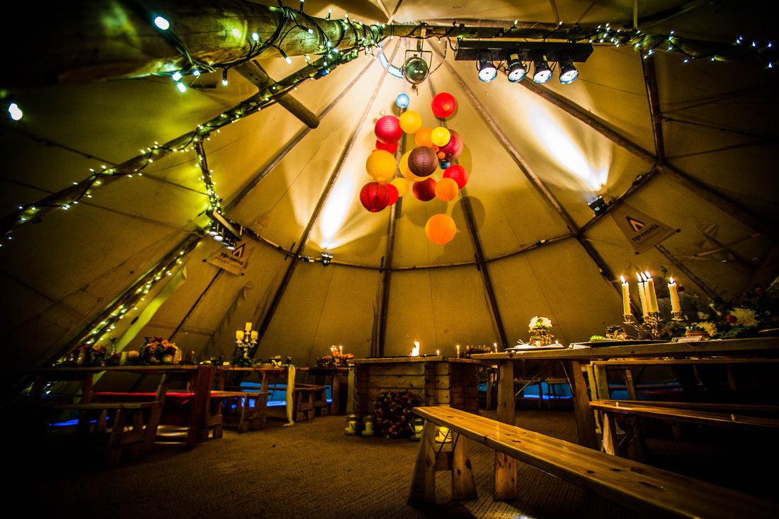 Side view of tipi with tables and lanterns setup