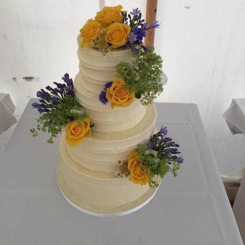 Buttercream cake finished with yellow & blue fresh flowers