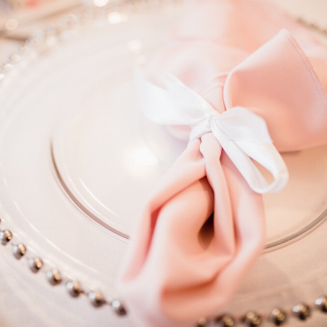 Clear charger plate and pale pink napkin
