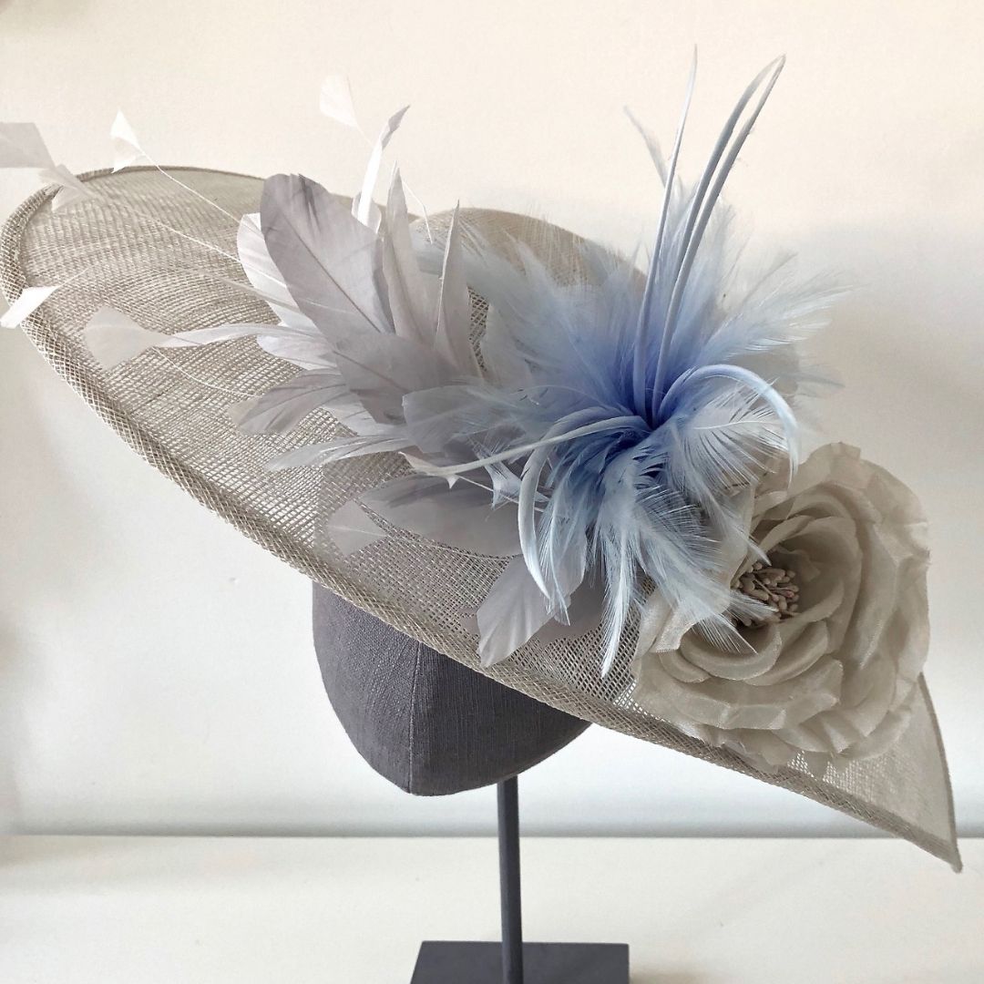 Light grey hatinator with blue feather and grey flowers
