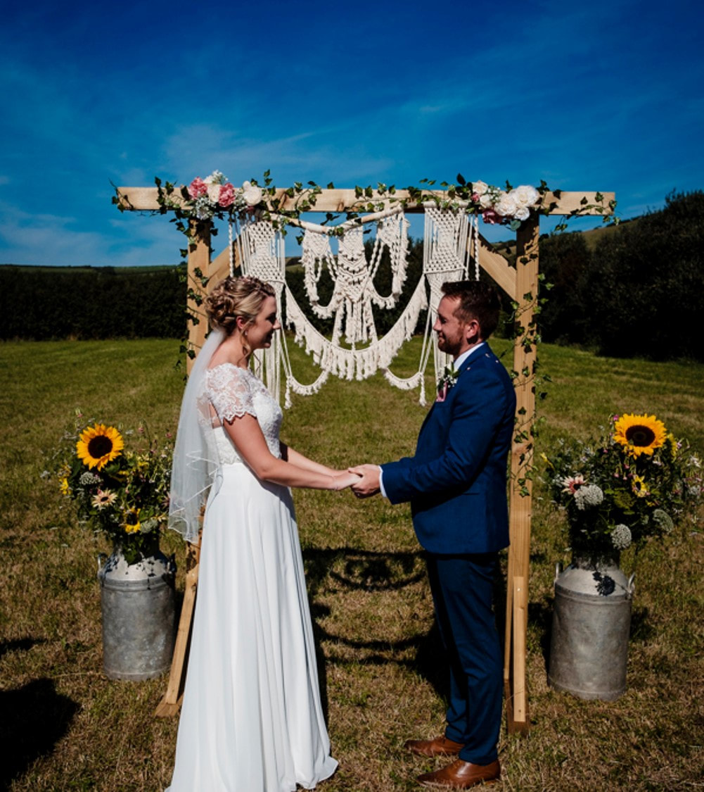 Macramé hanging arch with bride & groom in front