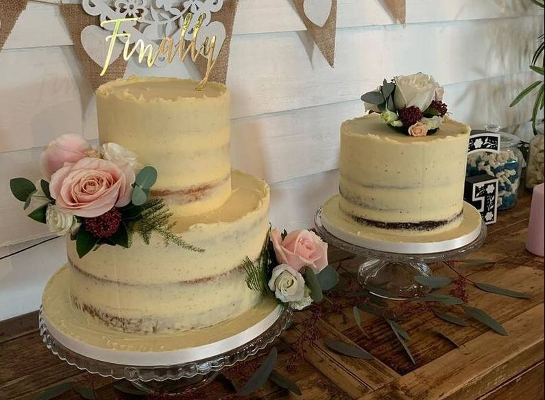Two semi naked wedding cakes with pink fresh flowers