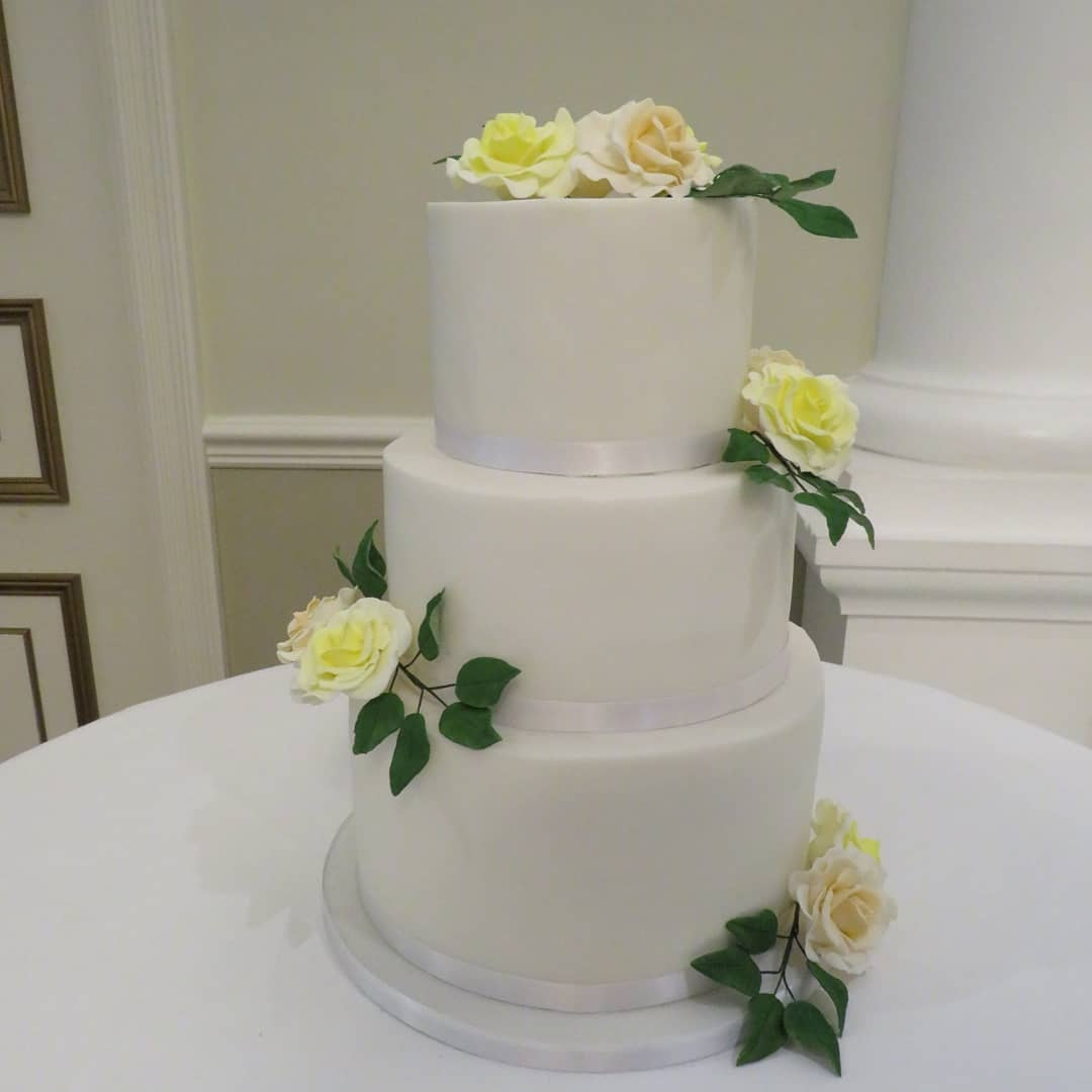 Fondant wedding cake with yellow & peach sugar flowers